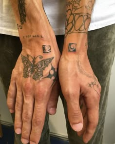 two people with tattoos on their hands