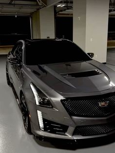 the front end of a silver cadillac parked in a garage