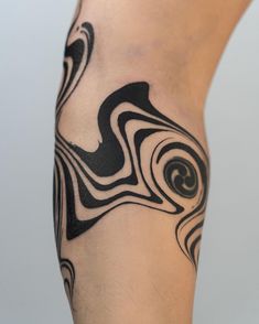 a man's leg with black and white swirls on the side, tattoo style