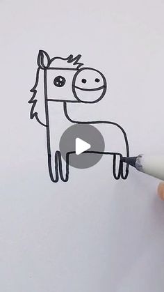 someone is drawing a cartoon horse on the white paper with a marker and it looks like they are smiling