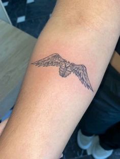 a man's arm with a tattoo on it that has an eagle flying in the sky