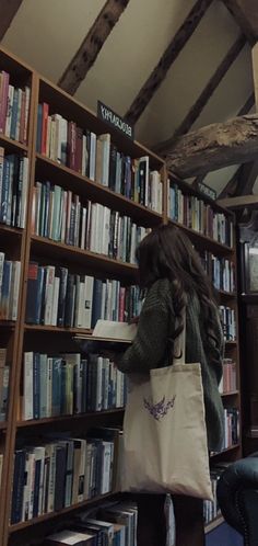 a woman standing in front of a bookshelf with a bag on her shoulder