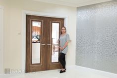 a woman standing in front of a door with her hand on her hip and looking at the camera