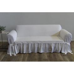 a white couch sitting on top of a hard wood floor