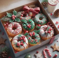 a box filled with lots of decorated doughnuts next to christmas decorations and candles