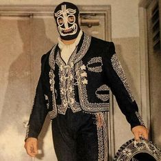 a man in a black and white costume with a mask on walking down the runway