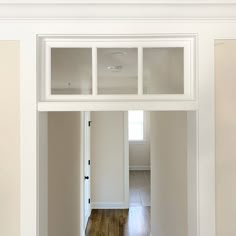 an empty room with white walls and wooden floors