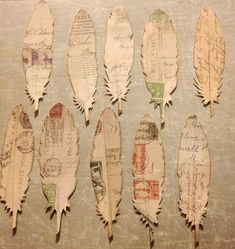 old paper feathers are arranged in a row on a table with writing all over them