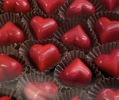 there are many heart shaped chocolates in the tray together, and one is red