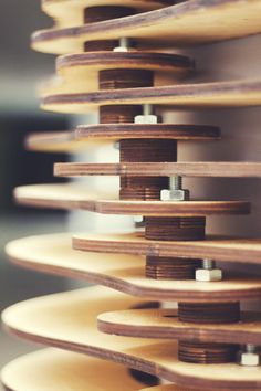 several skateboards stacked on top of each other in a room with wooden boards hanging from the ceiling