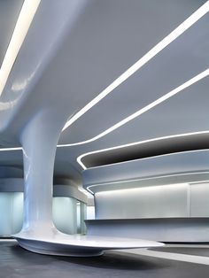 the interior of a modern building with white walls and ceiling lights on either side of it