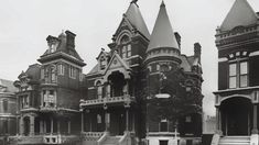 an old black and white photo of some very big houses in the day time,