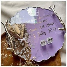 a purple plate that has some silver decorations on top of it, and the date is written in white