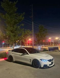 a white car is parked on the street at night