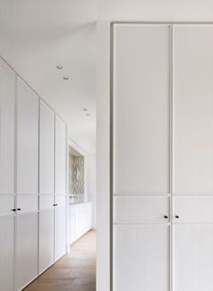 an empty room with white closets and wood flooring