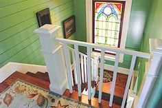 an aerial view of the stairs and stained glass window in this home's entryway