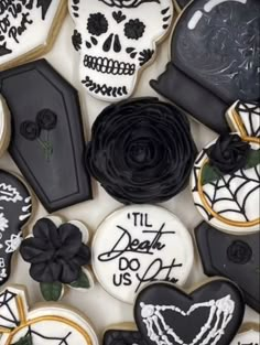 decorated cookies with black and white icing are arranged in the shape of sugar skulls