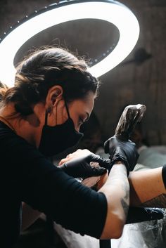 a woman getting her tattoo done by someone