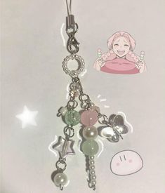 a keychain with charms attached to it's side and a cartoon character on the back