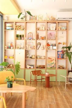 a living room filled with furniture and lots of shelves on the wall next to a table