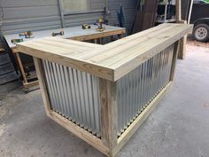 a wooden table with metal slats on it in a garage next to other woodworking tools