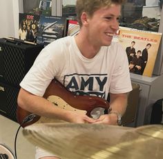 a young man sitting in front of a drum set