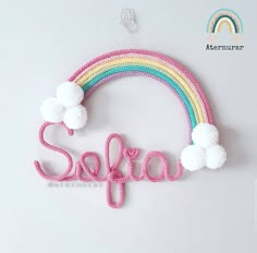 the word saffa spelled with pom poms in front of a rainbow