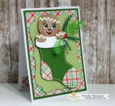 a handmade christmas card with a ginger in a stocking and pine branch on it