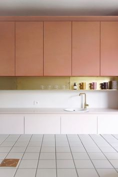 an empty kitchen with pink cabinets and white tile flooring on the countertop,