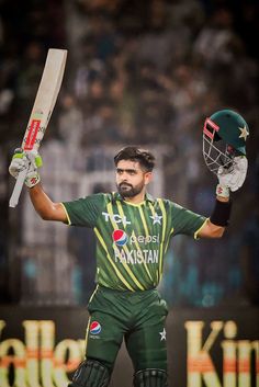 the pakistan cricket player is holding his bat and helmet