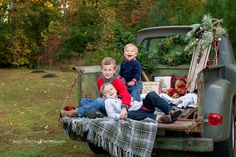 three children sitting in the back of an old truck