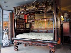 an antique bed frame with paintings on the wall