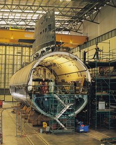 an airplane is being worked on in a large building with scaffolding around it