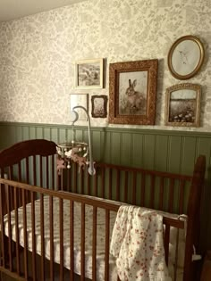 a baby crib in a room with pictures on the wall