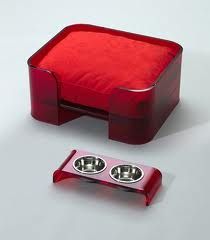 a red dog bowl holder with two bowls on it and one in the middle is empty