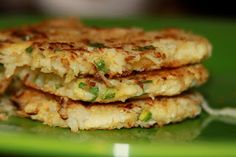 three crab cakes stacked on top of each other in a green plate with a fork