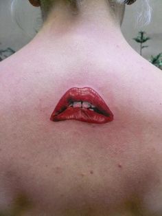 the back of a woman's neck with red lipstick painted on her upper lip