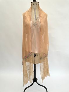 "This very pretty 1920s shawl or long scarf is made from silk chiffon and is light as a feather when worn. The main colour is a pale peach, with appliqué flowers in shades of pink, green and blue which are stitched with gold coloured metallic thread. Each end of the shawl has a deep border of lace with scalloped edges. There is a seam/stitch line across the centre of the shawl, both this and the edges of the shawl are machine stitched.  It measures 92\" inches long by 21\" inches wide, please check that the size will meet your needs before you purchase. It is in very good overall condition, there are a couple of very feint pale surface marks when it is held up against a strong light and I can see a small hole towards the border (please see photo 10). Please see all the images and zoom in f 1920s Shawl, Festive Vintage Silk Shawl, Luxury Vintage Silk Shawl, 1920’s Shawl, 1940s Coat, Vintage Pink Shawl Scarves, 30s Dress, Shade Flowers, Stitch Lines