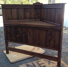 a wooden bed frame sitting on top of a piece of plywood