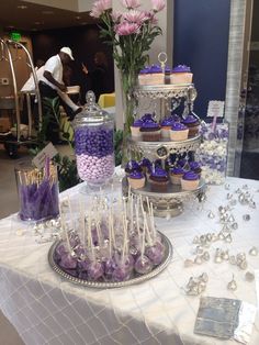 a table topped with lots of cupcakes and candy covered desserts on top of it