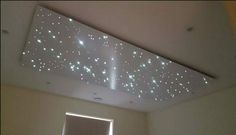 the ceiling is decorated with white lights and stars on it as well as a window