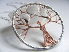 a silver and copper tree pendant on a chain