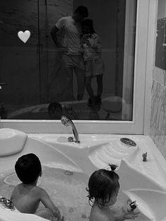 two children are playing in the bathtub