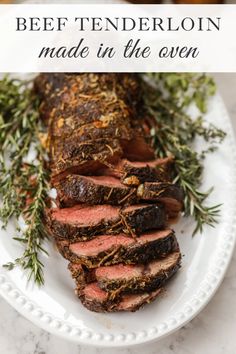 beef tenderloin on a white plate with rosemary sprigs and text overlay that reads beef tenderloin made in the oven