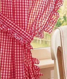 a red and white checkered curtain next to a window