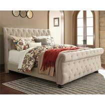 a white bed sitting on top of a wooden floor next to a window and rug