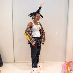 a woman standing in front of a wall with stuffed animals on it's feet