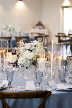 the table is set with candles, flowers and place settings for an elegant dinner party