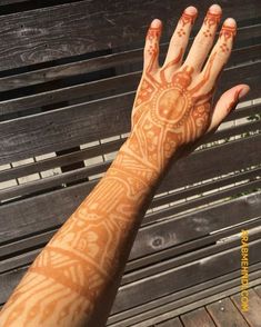 a woman's hand with hendix on it sitting on top of a wooden bench