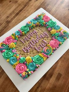 a birthday cake decorated with colorful icing on top of a white plate